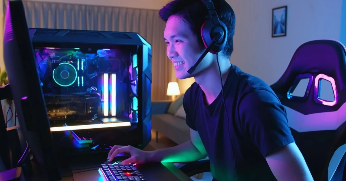 Gamer souriant avec casque audio devant son setup, illustration achat de jeux vidéo moins cher
